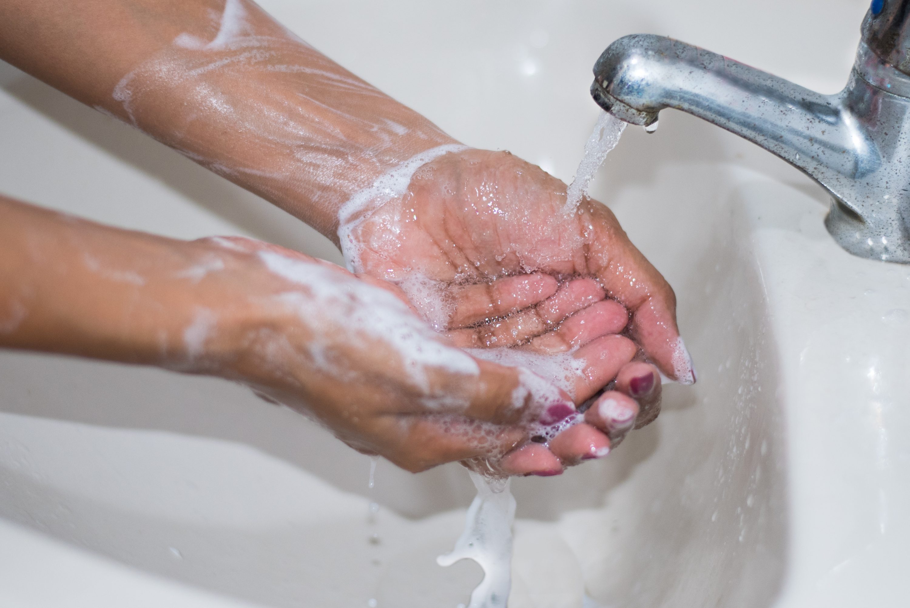 Image of washing hands. Please wash your  hands to prevent the spread of COVID-19.